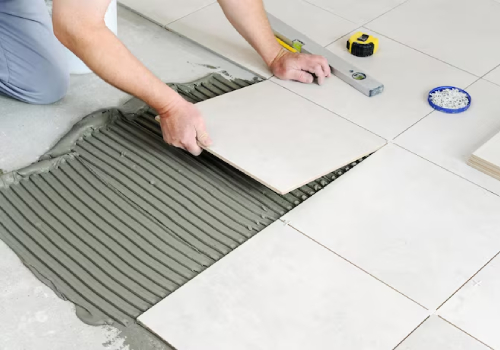 Local tiling expert laying floor tiles in home
